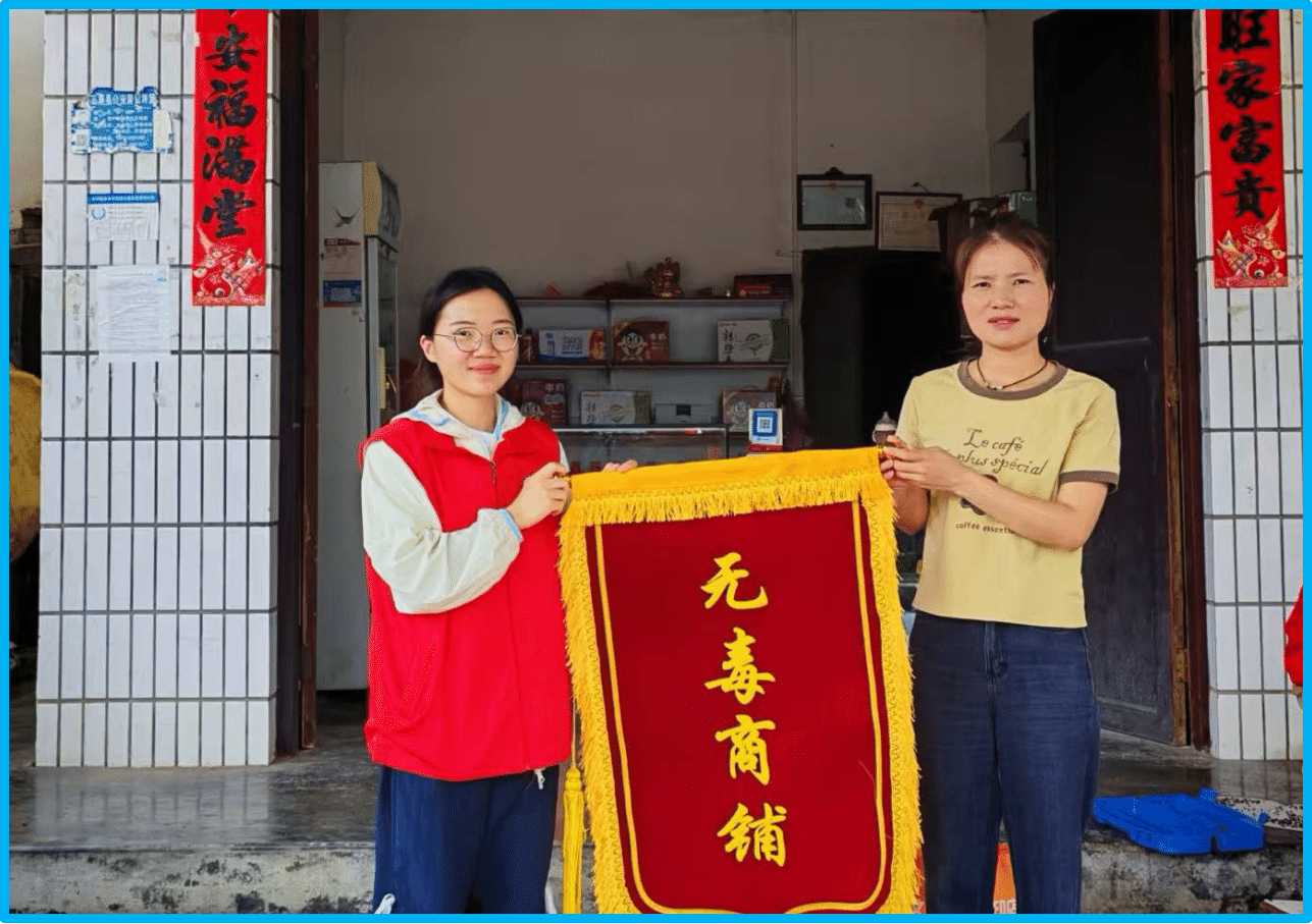 图为志愿者为村民赠送无毒商铺锦旗.png
