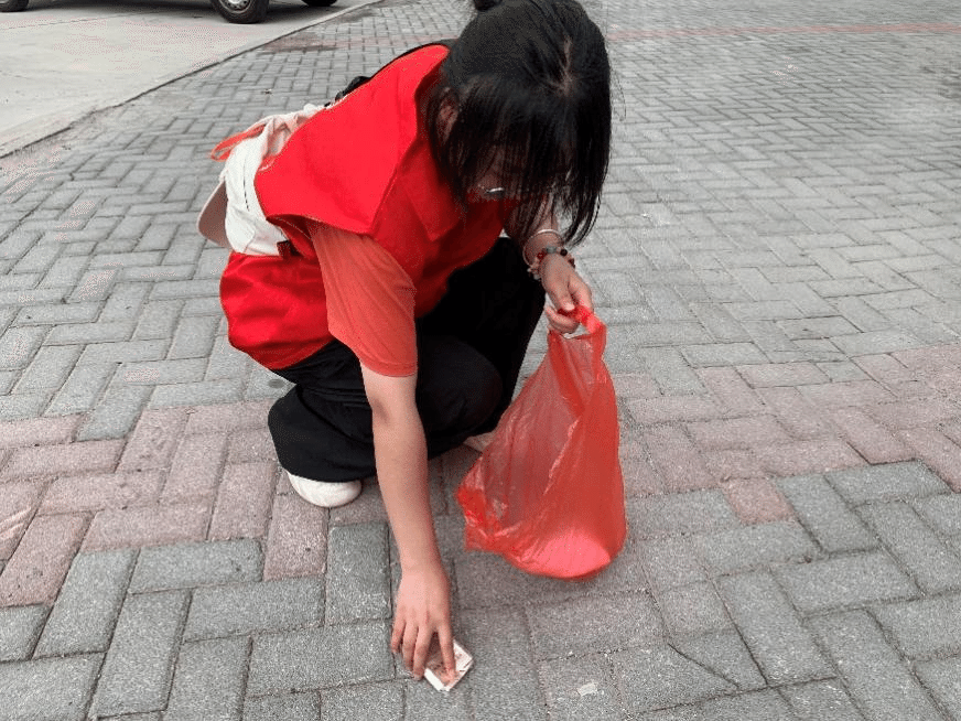 图为志愿者在社区捡拾垃圾.png 图为志愿者在社区捡拾垃圾.png