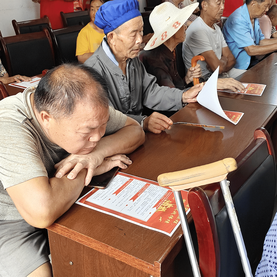 图为社区居民认真阅读党史宣传单.png 图为社区居民认真阅读党史宣传单.png