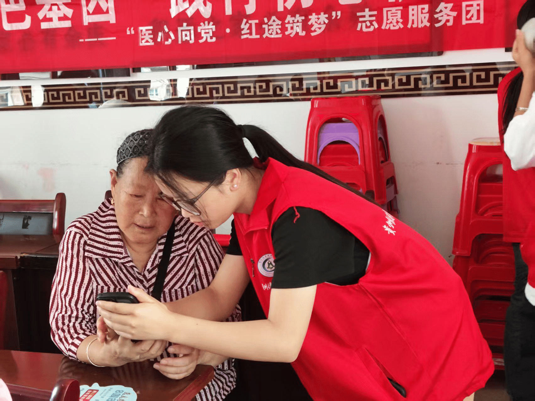 图为志愿者帮助老人调节手机.png 图为志愿者帮助老人调节手机.png