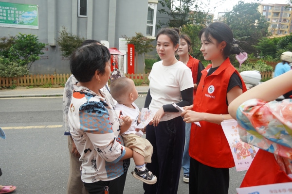 图：志愿者发放宣传单、与居民交流1.png