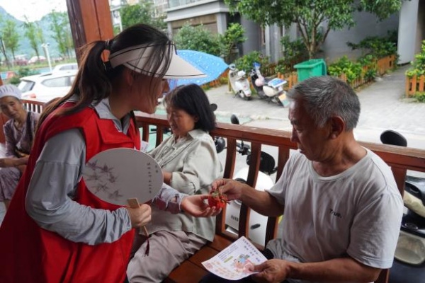 图：志愿者进行社区卫生服务、赠送中药文创产品3.png